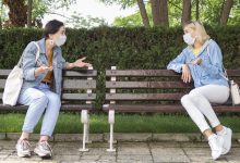 2 mujeres con distancia social hablando en un parque